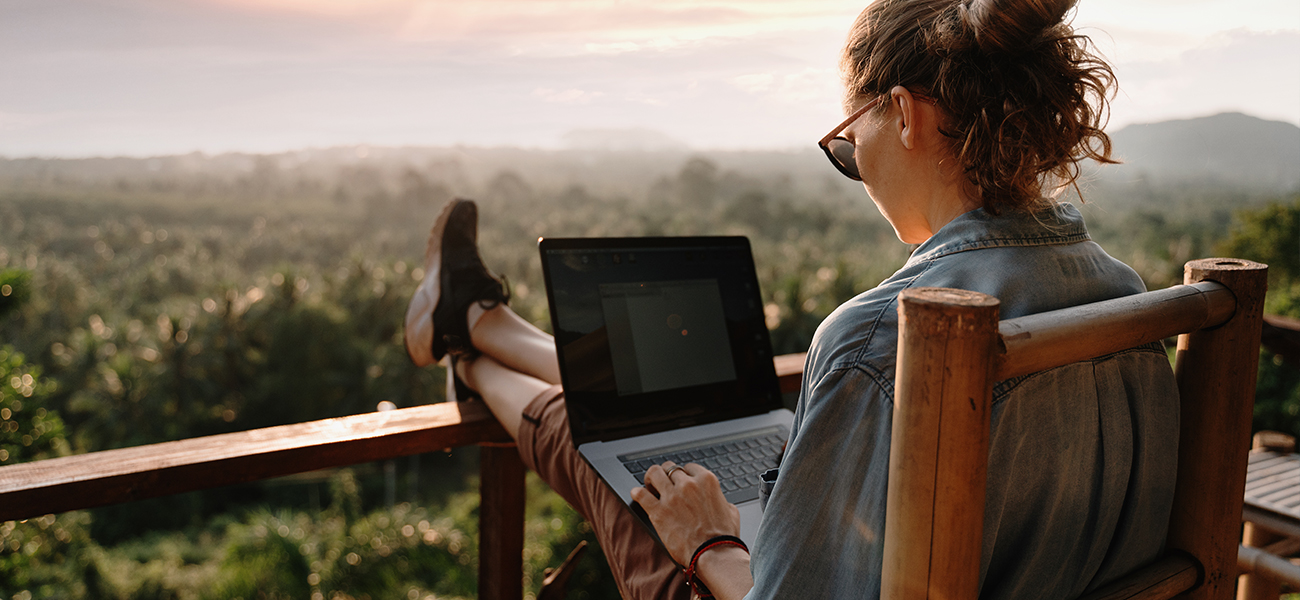 Woman working from her laptop with a mountainous view.