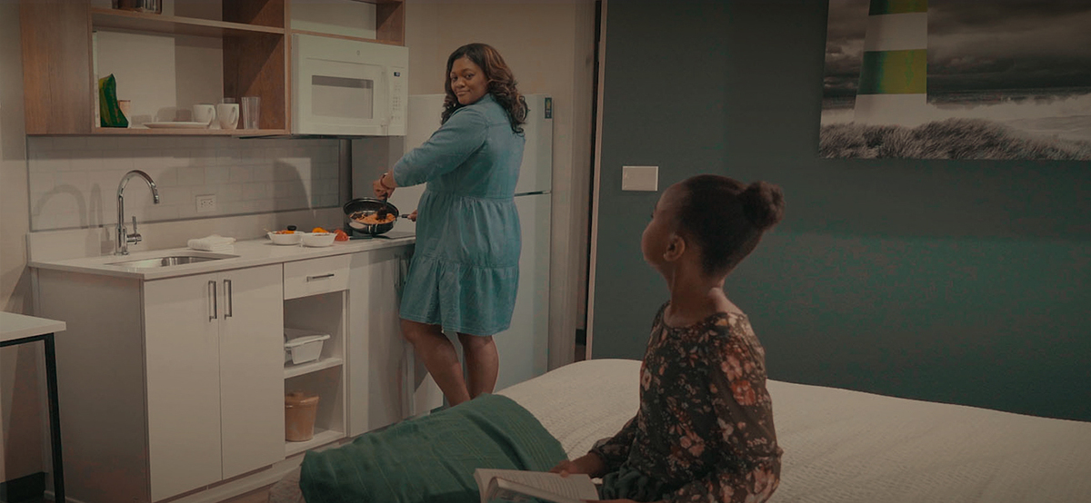 Mom making dinner for her daughter in a hotel room.