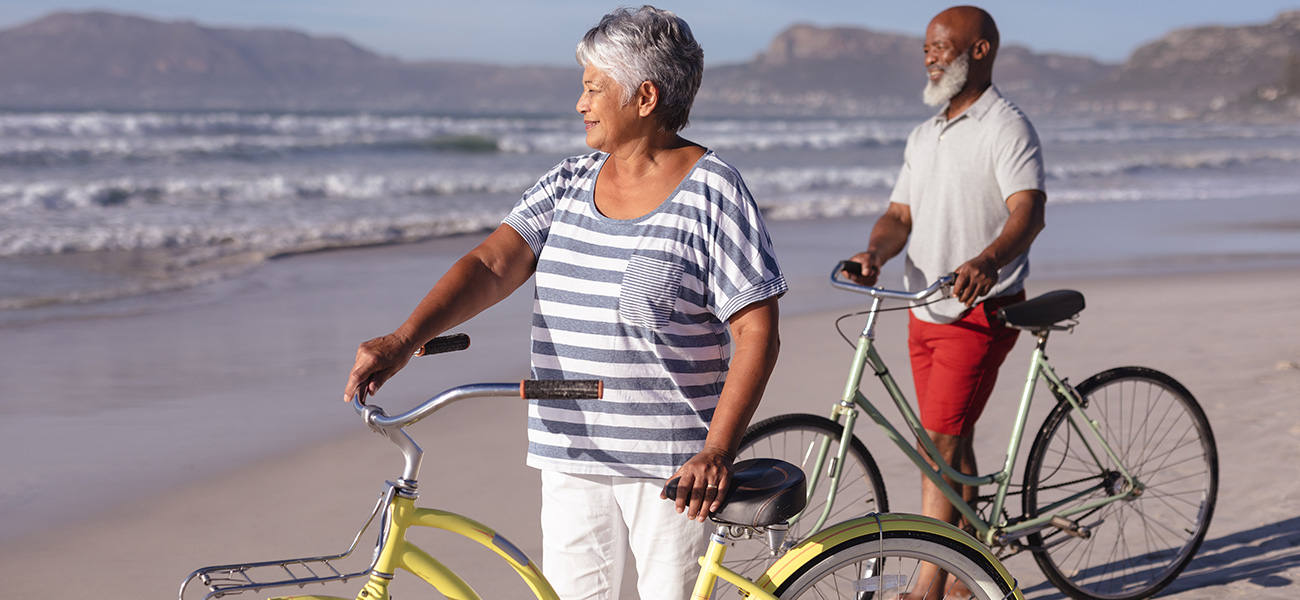 Couple riding bikes on the beach.