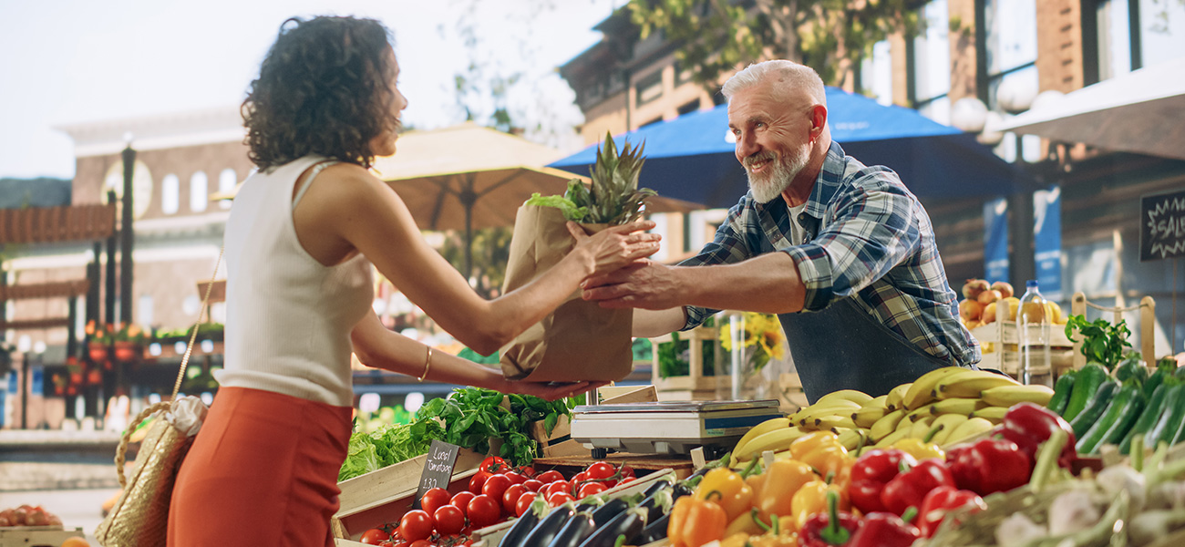 Lady buying produce at a farmers market.